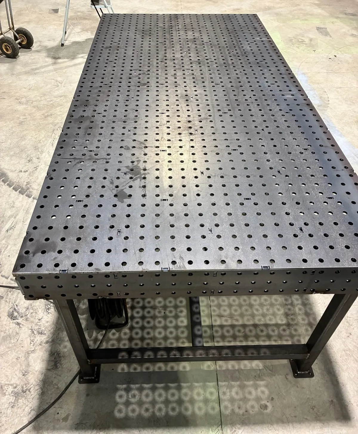 Table de soudage modulaire perforée, en acier, dans l'atelier.